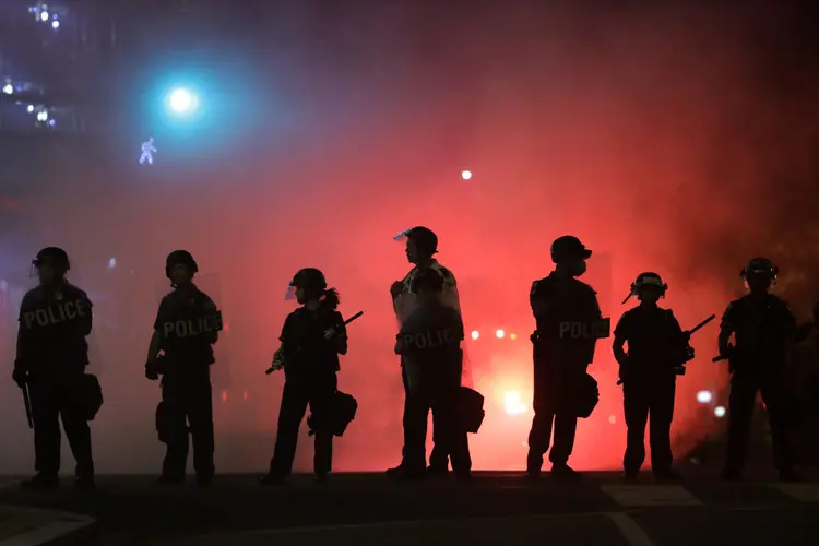 Policiais protegem a Casa Branca, em Washington, cercada por manifestantes na noite deste sábado (Alex Wong/Getty Images)