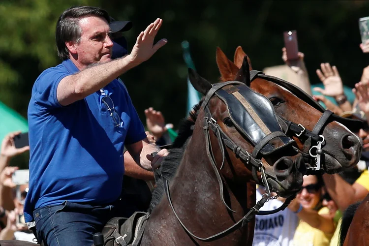 O presidente do Brasil, Jair Bolsonaro, monta um cavalo durante uma reunião com apoiadores protestando a seu favor, em meio ao surto de doença por coronavírus (COVID-19), em Brasília, Brasil, 31 de maio de 2020. (Ueslei Marcelino/Reuters)