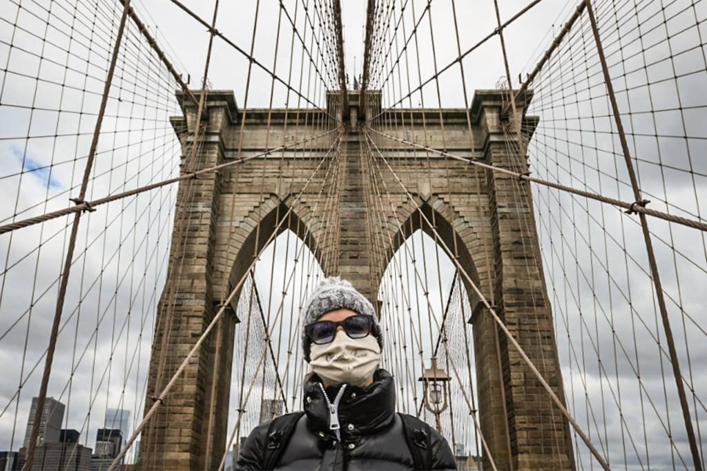 Pessoa de máscara em Nova York: maioria dos Estados norte-americanos relataram uma queda em novos casos da doença respiratória na semana encerrada em 17 de maio (AFP/Foto)