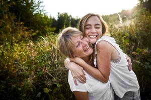 Happy mother and adult daughter hugging in the countryside