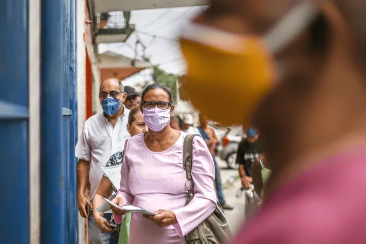 Pessoas de máscaras nas ruas: houve melhora na confiança em todas as faixas de renda familiar, exceto para as famílias mais pobres, que recebem até R$ 2,1 mil (Bloomberg / Colaborador/Getty Images)