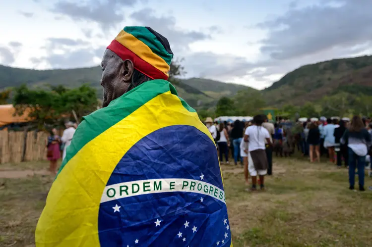Idoso brasileiro enrolado em bandeira do Brasil no Rio de Janeiro  (Igor Alecsander/Getty Images)