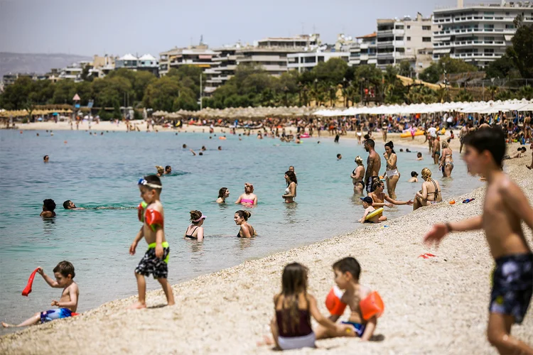 Pessoas aproveitam sábado de sol em praia na Grécia, com a gradual reabertura do país em meio à pandemia do coronavírus. 16/05/2020 (Costas Baltas/Reuters)