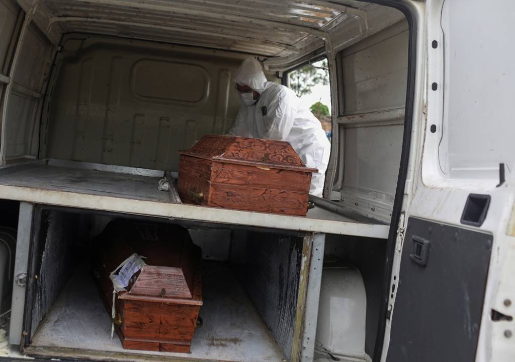 Agente funerário retira caixões de veículo para enterros em cemitério de Manaus
28/04/2020 (Bruno Kelly/Reuters)