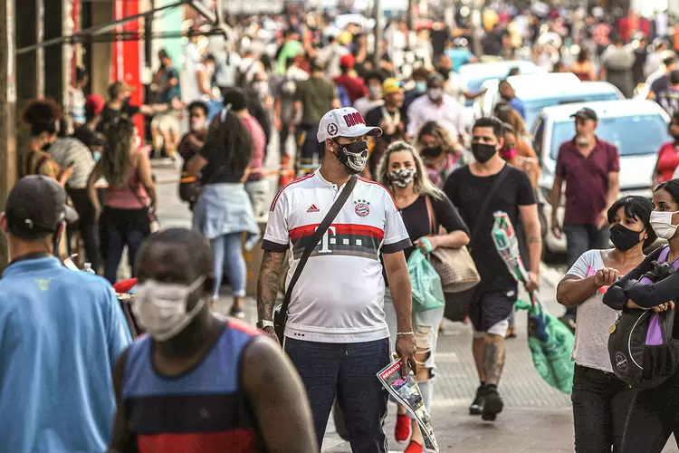 Homem usa máscara em meio à multidão na reabertura do comércio em SP: (Amanda Perobelli/Reuters)