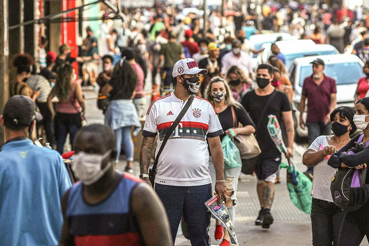 Homem usa máscara em meio à multidão na reabertura do comércio em São Paulo. 11 de junho de 2020. (Amanda Perobelli/Reuters)
