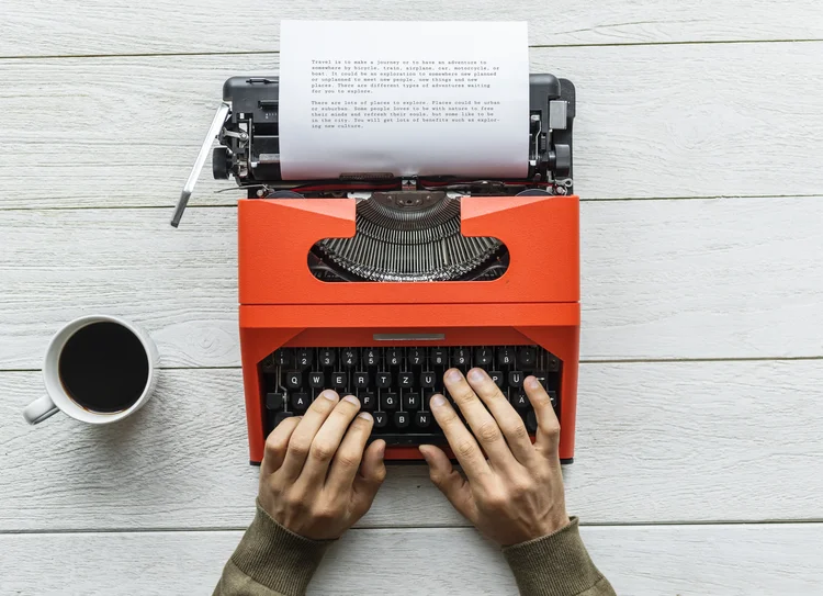 Aerial view of a man typing on a retro typewriter (Designed by rawpixel.com / Freepik/Creative Commons)