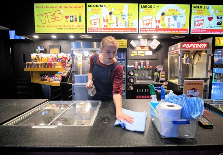 Funcionária limpa superfície de balcão de cinema em Melbourne: Austrália registra 7.500 casos de COVID-19 e 102 mortes (Image/Daniel Pockett/Reuters)
