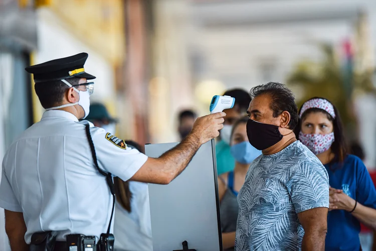 Homem tem temperatura checada em entrada de shopping de Brasília (André Borges/Getty Images)