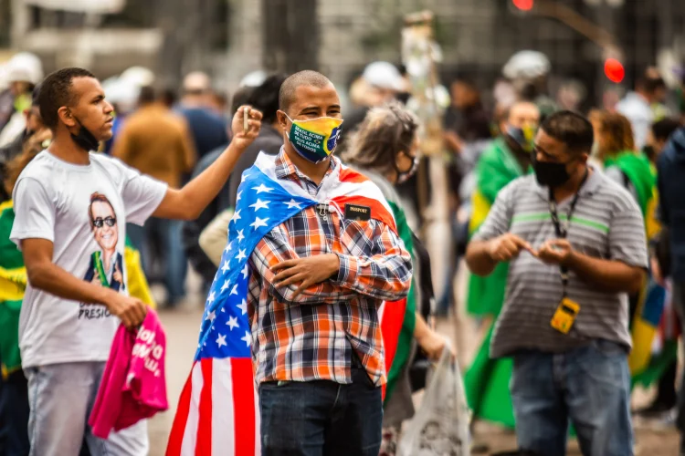 Homem com a bandeira americana em manifestação a favor do governo: em cidades pequenas, relação formal com as siglas é maior (VAN CAMPOS/Estadão Conteúdo)