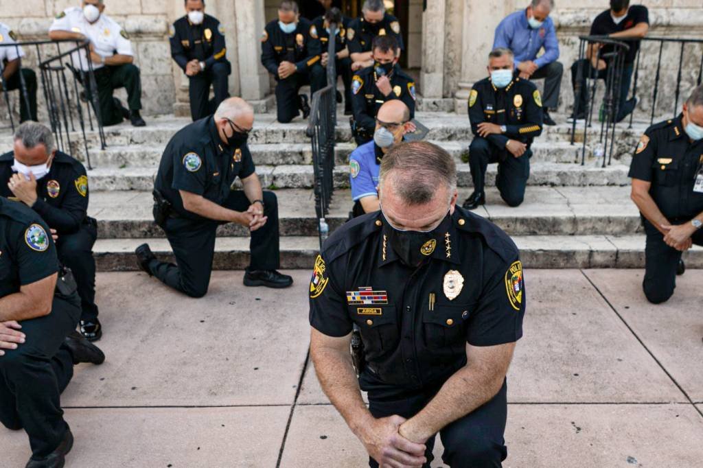 Policiais se ajoelham para os manifestantes na Flórida: protestos pela morte de George Floyd tomaram as ruas dos Estados Unidos (EVA MARIE UZCATEGUI/AFP)