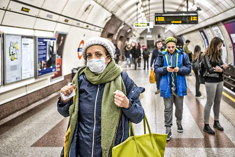 Mulher de máscara em metrô do Reino Unido: ao contrário de um menor número de mortes publicado diariamente pelo governo, as certidões de óbito incluem casos suspeitos (Bryn Colton/Getty Images)