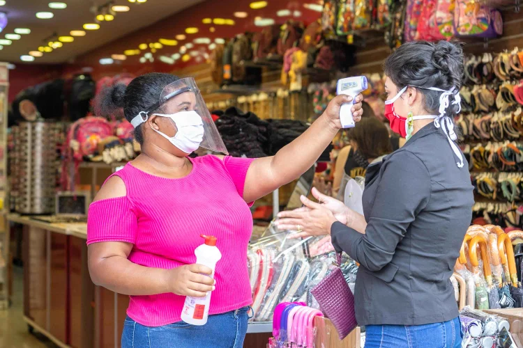 Consumidora tem a temperatura corporal aferida por funcionária de loja antes de acessar o   estabelecimento, na Avenida Domingos de Moraes São Paulo, na manhã desta quarta-feira, 10   de junho de 2020. A Prefeitura da capital paulista autorizou o funcionamento do comércio   de rua a reabrir a partir de hoje. As lojas deverão ficar abertas entre 11h e 15h.   10/06/2020 (PATRICIA BORGES/Estadão Conteúdo)