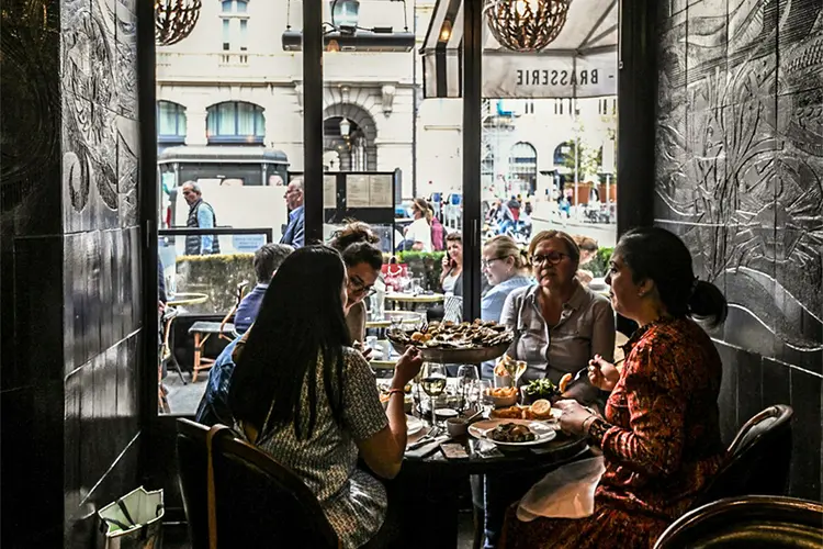 Pessoas em restaurantes em Paris: reabertura da França começa e estabelecimentos podem receber clientes (Foto/AFP)