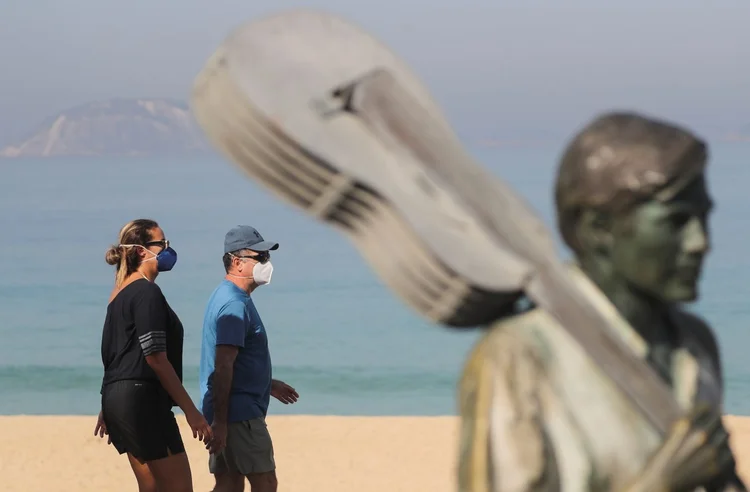 Na atual fase de flexibilização do município, só é permitido tomar banho de mar e praticar esportes aquáticos, como o surfe. (Sergio Moraes/Reuters)