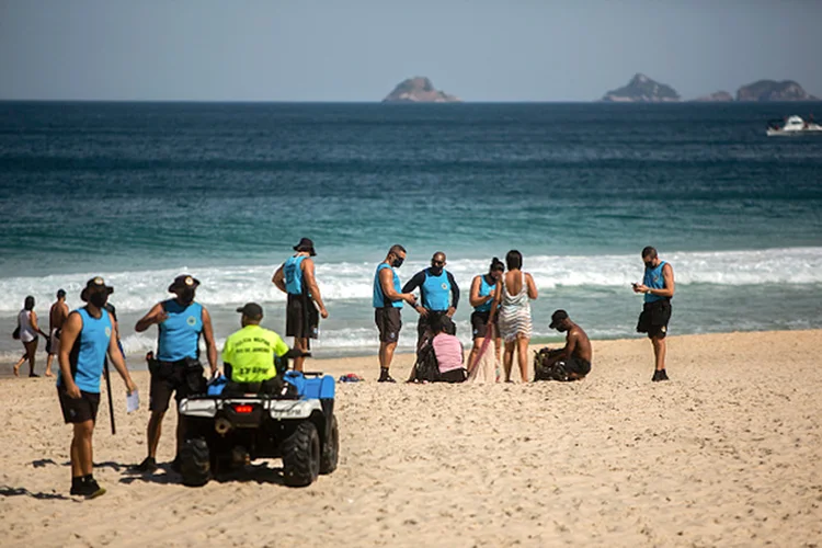 RIO DE JANEIRO, BRAZIL - JULY 12: City hall inspectors warn and notify beach goers of new rules at Arpoador Beach amidst the coronavirus (COVID-19) pandemic on July 12, 2020 in Rio de Janeiro, Brazil. The practice of physical activities on boardwalks and individual sports at sea is allowed. However, the use of chairs and tents on the sand is still prohibited. Mayor Marcelo Crivella warned of the intensification of inspection and the imposition of a fine for those who do not comply with the rules. (Photo by Bruna Prado/Getty Images) (Bruna Prado/Getty Images)