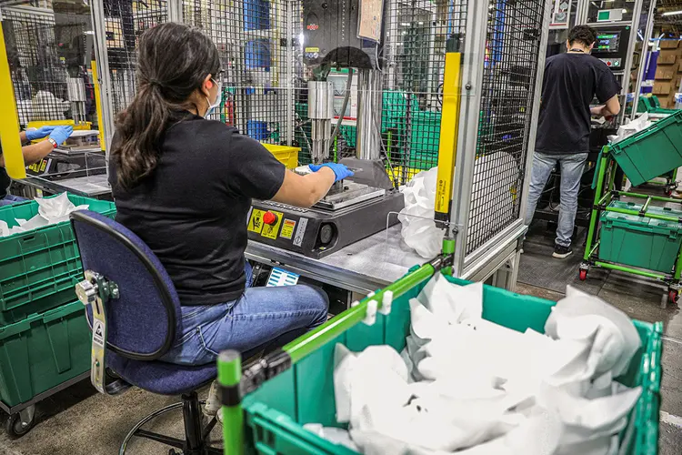 Trabalhadores fabricam máscaras protetoras em linha de montagem enquanto o presidente dos EUA, Donald Trump, visita instalação da Honeywell em Phoenix, Arizona, EUA, em 5 de maio de 2020.   (Tom Brenner/Reuters)