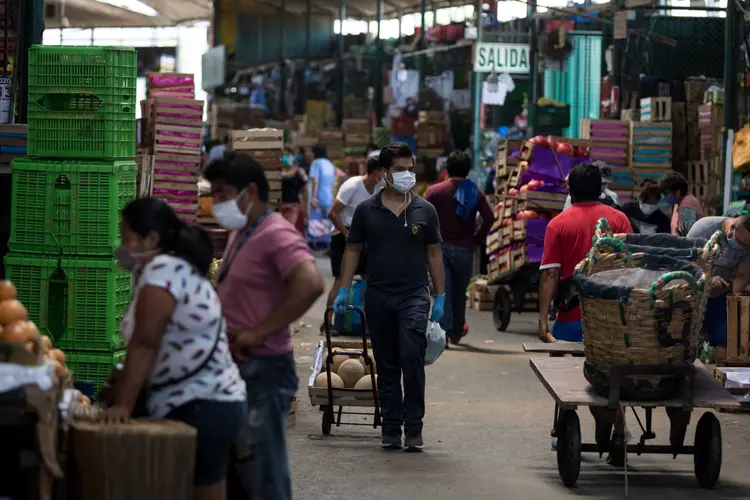 Pessoas usam máscaras protetoras em um mercado de Lima, no Peru, na sexta-feira, 17 de abril de 2020. (Angela Ponce/Bloomberg)