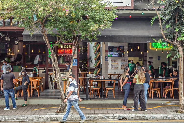 Pessoas com máscaras de proteção em frente a restaurante, em São Paulo, 6 de julho de 2020 (Jonne Roriz / Bloomberg/Getty Images)