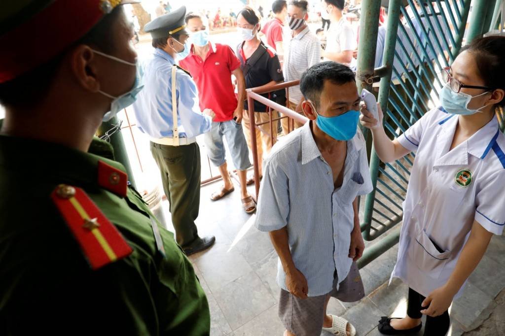 Torcedor tem temperatura checada antes de entrar em estádio no Vietnã: país vem tendo sucesso no combate à covid-19 (Reuters/Kham/File Photo)