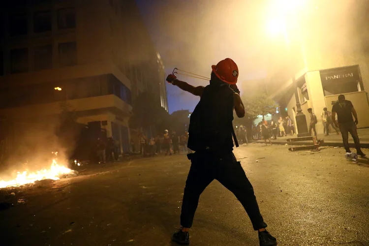 Líbano: manifestante arremessa pedras durante protesto (Hannah McKay/Reuters)