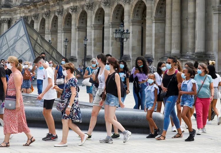 Visitantes usando máscaras protetoras fazem fila para entrar na Pirâmide do Louvre (Charles Platiau/Reuters)
