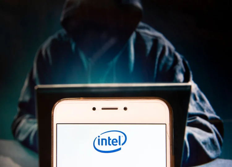 HONG KONG, CHINA - 2018/11/27:  In this photo illustration, the American multinational corporation and microprocessor technology company Intel logo is seen displayed on an Android mobile device with a figure of hacker in the background. (Photo Illustration by Miguel Candela / SOPA Images/SOPA Images/LightRocket via Getty Images) (SOPA/Getty Images)