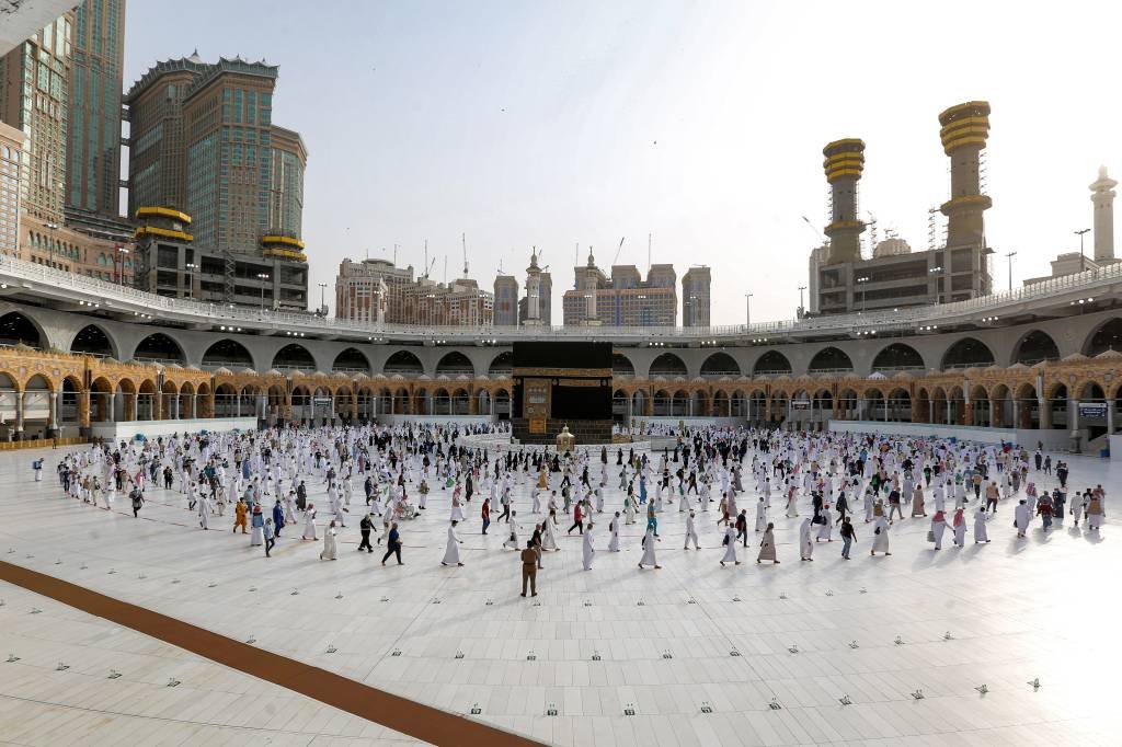 Muçulmanos caminham em volta da Kaaba, na cidade sagrada de Meca, na Arábia Saudita: ao invés de milhões de visitantes, este ano a peregrinação foi reduzida a milhares por causa da pandemia do coronavírus (STR/AFP)