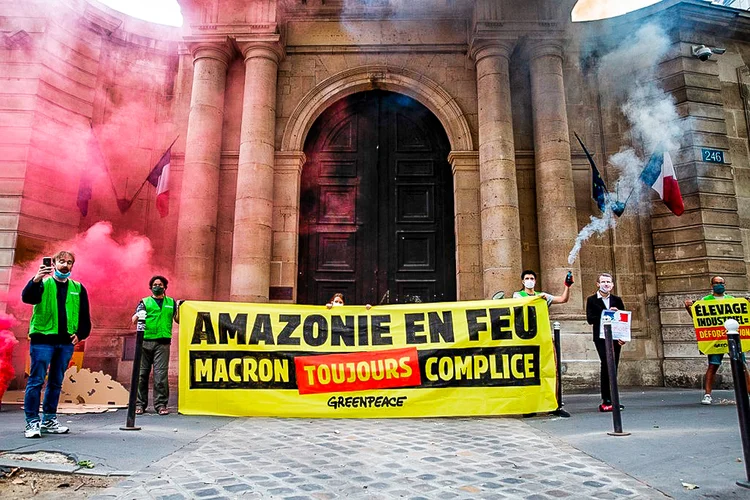 "Amazônia em chamas, Macron continua cúmplice", diz cartaz em frente à sede do Ministério da Transição Ecológica (Raphael Lafargue/AFP)