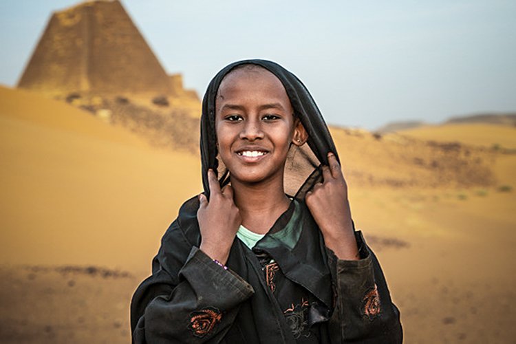 Sudanesa em frente a pirâmides do Sudão, ao lado do Egito; país foi governado por rainhas (Eric Lafforgue/Getty Images)