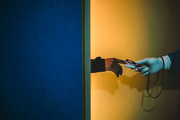 Profissional de saúde lê sinais vitais de um paciente com covid-19, em quarentena dentro de hotel, em Caracas, 18 de agosto de 2020. (Matias Delacroix/Bloomberg)