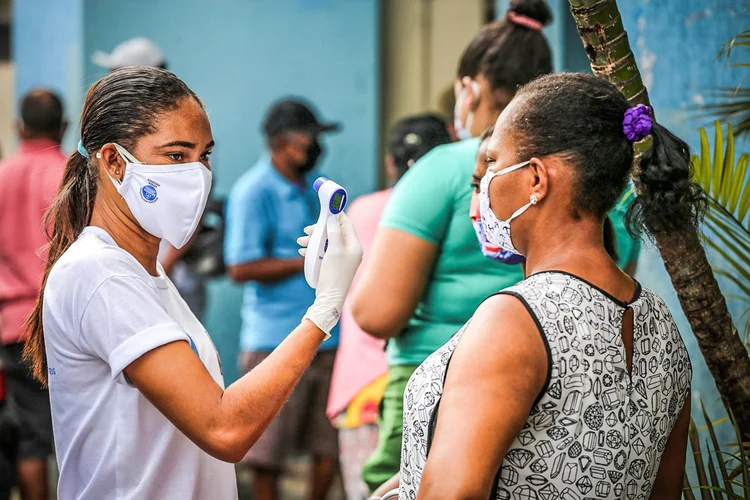 Pessoas têm temperatura aferida e usam máscaras em lugares públicos. No total, o Brasil chegou a 151.063 mortes e 5.114.823 casos confirmados de covid-19 (Bruno Concha/Secom/Divulgação)