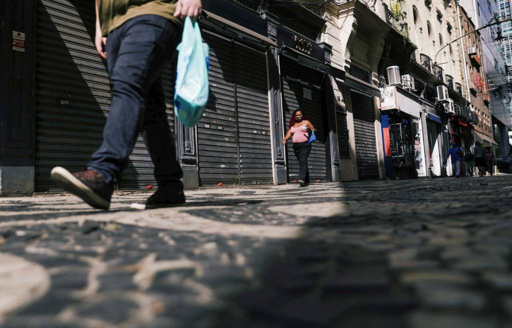 Pessoas passam por lojas fechadas no centro do Rio de Janeiro (Ricardo Moraes/Reuters)