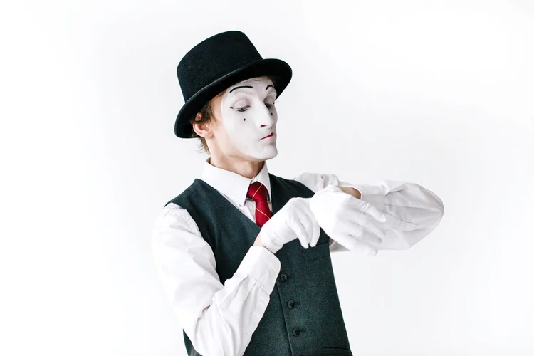 Mime in black hat and waistcoat looks at the invisible watch (Designed by v.ivash / Freepik.com/Creative Commons)