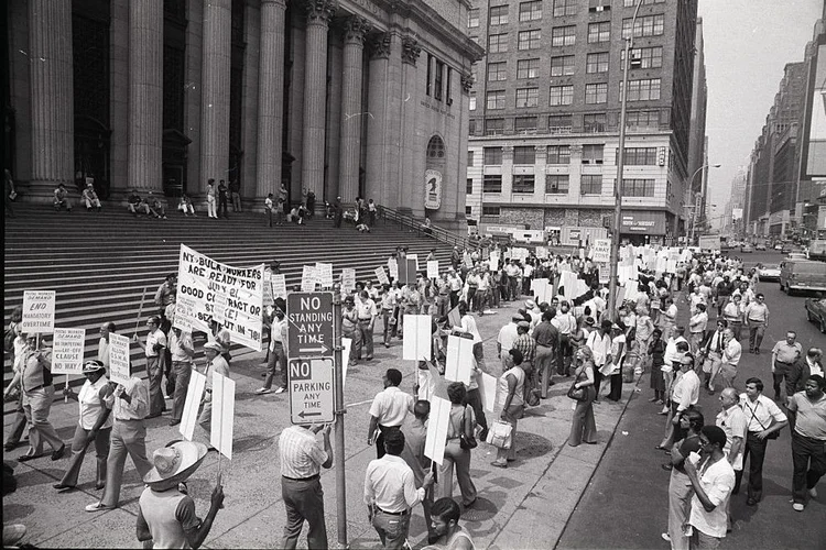 Funcionários dos correios carregando cartazes manifestam-se do lado de fora da agência pricipal, na 34th Street com a 8th Avenue, Nova York, em 20 de julho de 1978.  (Bettmann / Colaborador/Getty Images)