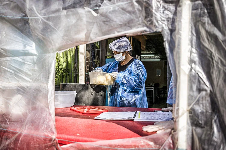 Santiago, Chile: assistente social prepara comida em uma cozinha comunitária, na segunda-feira, 17 de agosto de 2020. (Tamara Merino/Bloomberg)