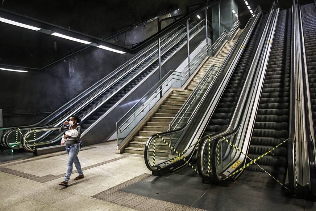 Isolamento social: pedestre de máscara protetora caminha por uma estação de metrô quase vazia no Rio, na segunda-feira, 20 de abril de 2020 (Andre Coelho / Bloomberg/Getty Images)