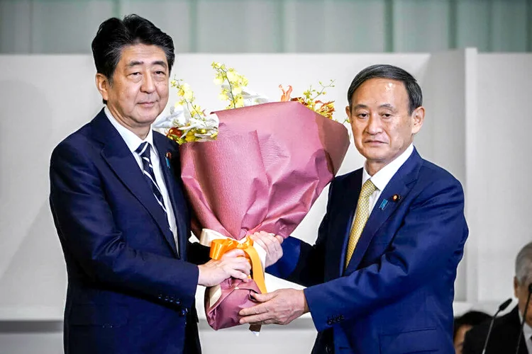 Abe e Suga (à dir.) após eleição do novo líder do partido: Suga é conhecido por seu punho de ferro (Pool / Equipe/Getty Images)