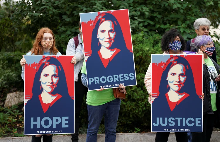 Manifestantes favoráveis a Barrett levam placas da juíza em frente ao Senado: ela é apoiada por grupos conservadores, religiosos e contrários ao direito ao aborto (Kevin Lamarque/Reuters)