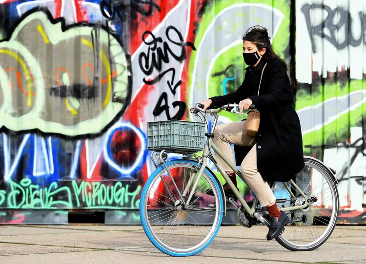 Mulher passeia de bicicleta por rua de Amsterdã, após governo holandês decretar novas medidas de combate ao coronavírus (Piroschka van de Wouw/Reuters)