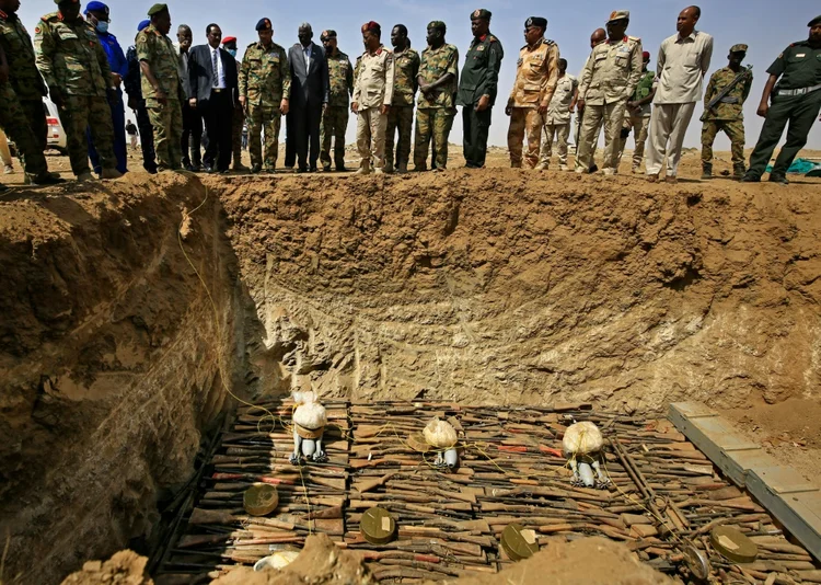 Militares sudaneses observam armas coletadas de cidadãos antes da destruição na base Hajar al-Asal, no estado do Rio Nilo, a 200 km da capital Cartum, em 29 de setembro de 2020 (AFP/AFP)