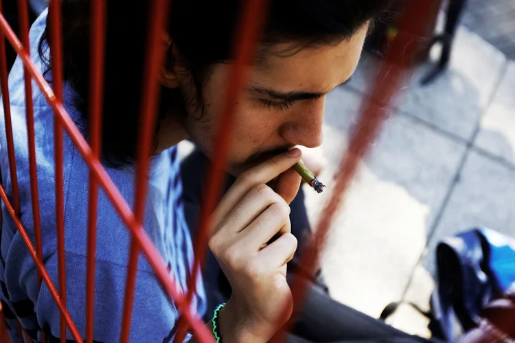 Homem fuma maconha do lado de fora do Senado mexicano, na Cidade do México (Carlos Jasso/Reuters)