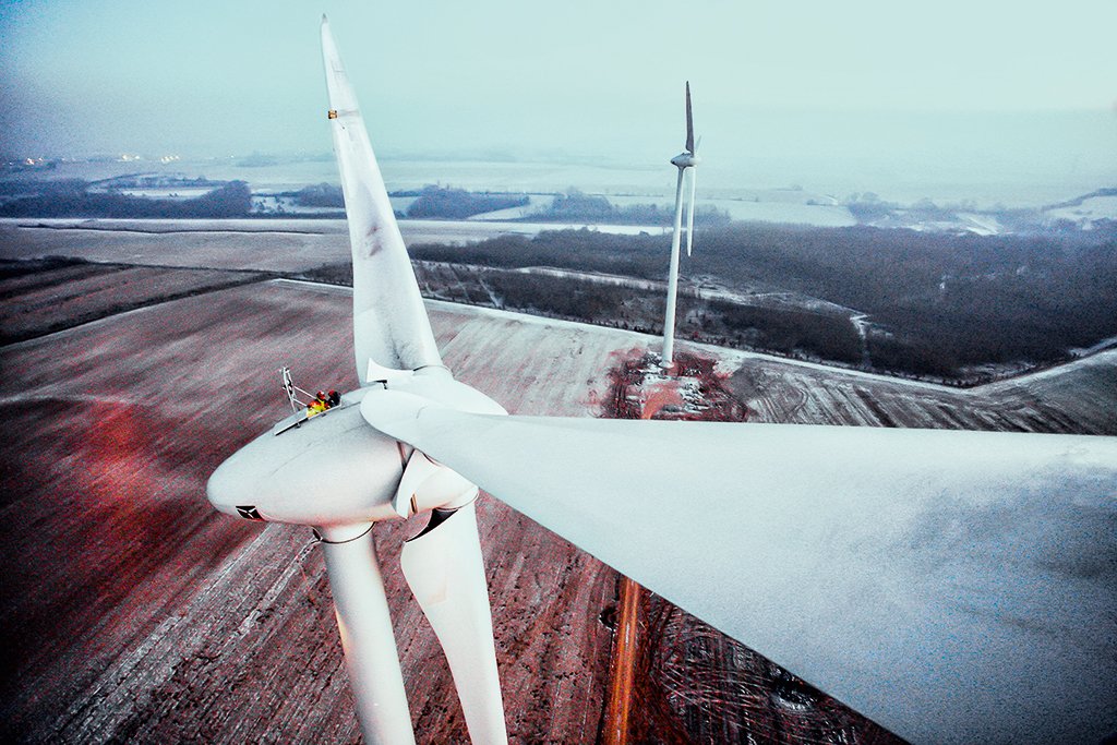 Workers put the finishing touches on a power-generating windmill turbine in a wind farm in Fruges