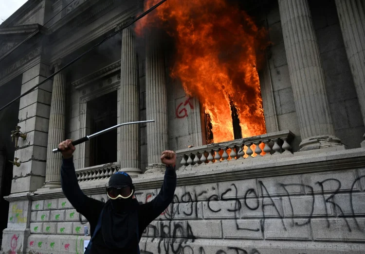 Manifestante em frente ao congresso incendiado na Guatemala  (Agence France-Presse/AFP)