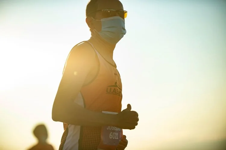 An athlete wearing a face mask to prevent the spread of coronavirus warms up before the start of the Merce run in Barcelona on September 20, 2020. - The race "La Cursa de la Merce" runs across 10km in Barcelona city and this year is dedicated to the fight against COVID-19. (Photo by Josep LAGO / AFP) (Photo by JOSEP LAGO/AFP via Getty Images) (JOSEP LAGO/AFP via Getty Images/Getty Images)