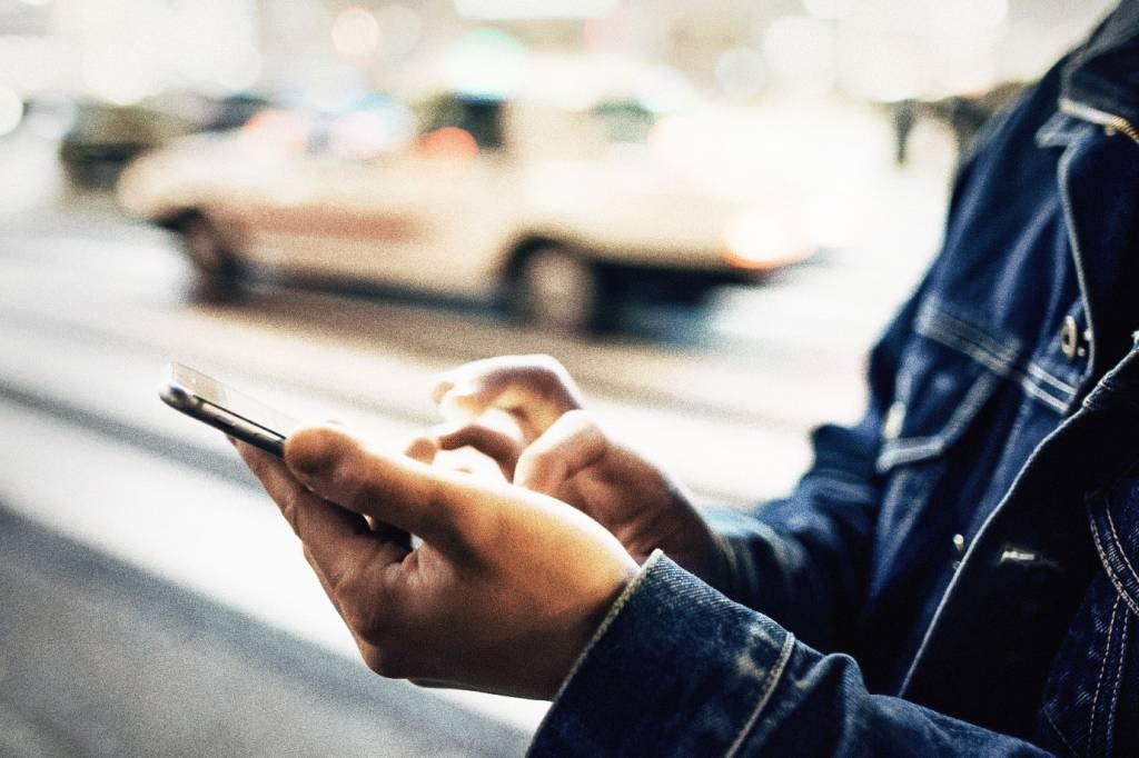 Homem com celular: app filtra fundos e os reúne em carteiras por perfil de investidor ou segmento do mercado (Bronek Kaminski/Getty Images)