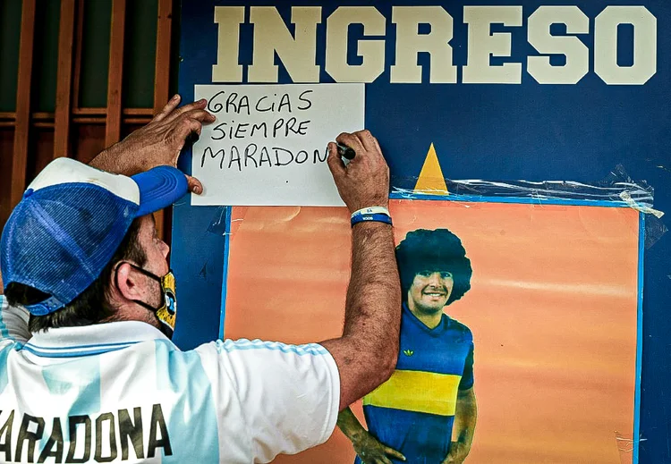 Fã de Maradona escreve mensagem para seu ídolo no lado de fora da Bombonera em 25 de novembro de 2020 (AFP/AFP)