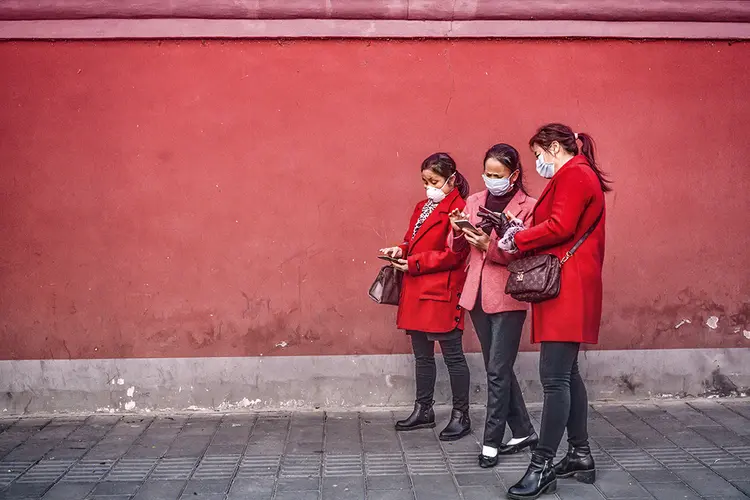 Pessoas usando smartphones na China: a tecnologia 5G impulsiona a conectividade nos negócios (Kevin Frayer/Getty Images)