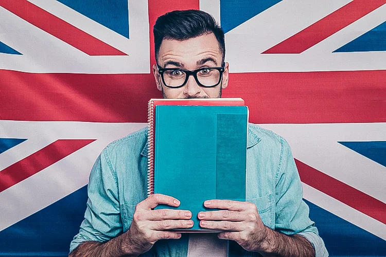 Homem estudando inglês na frente da bandeira do Reino Unido (Deagreez/Getty Images)