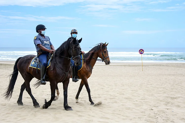 Policiais patrulham fechamento de praia em Durban, na África do Sul: país identificou nova cepa do coronavírus (Darren Stewart/Getty Images)